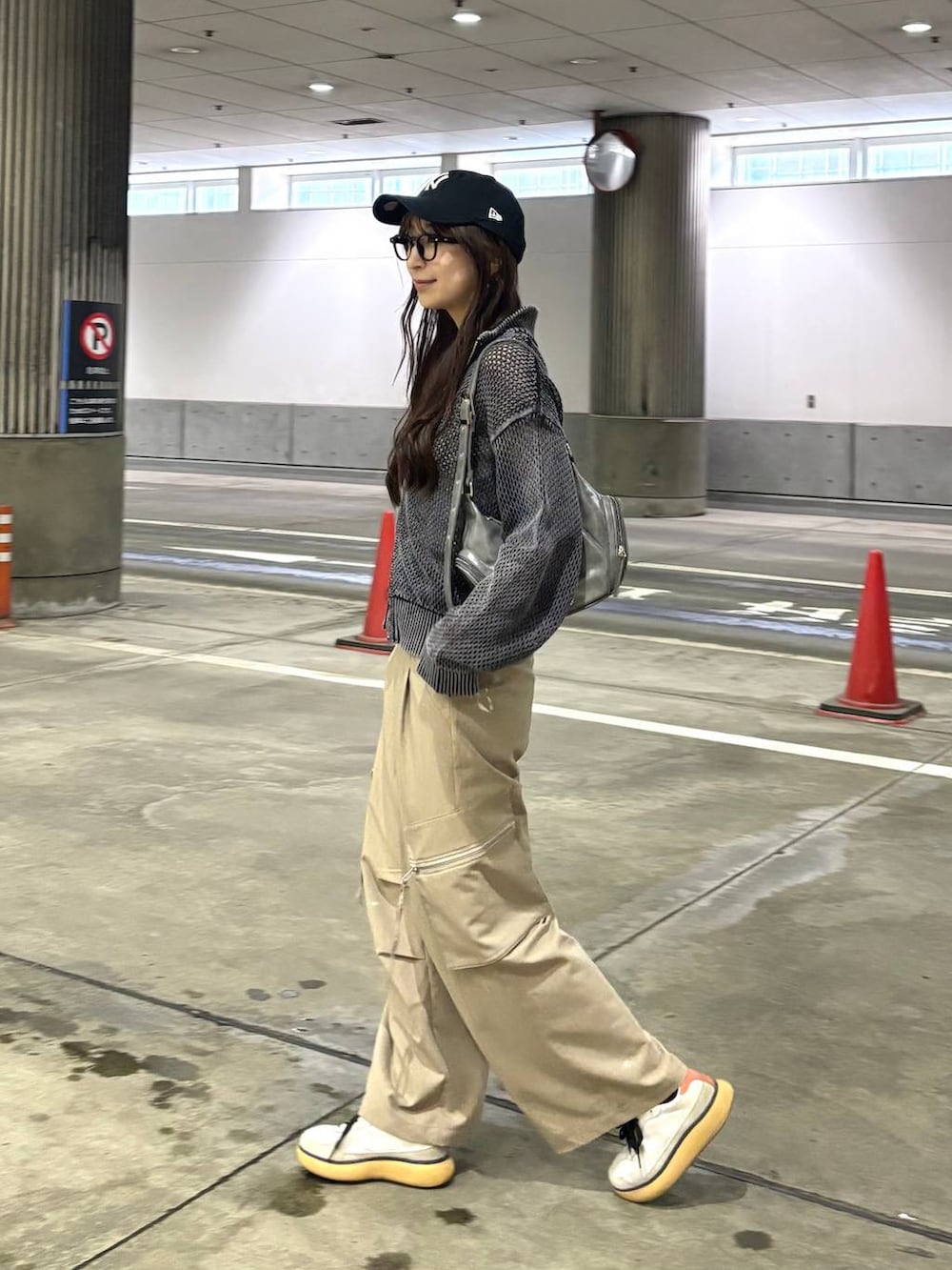 ブラック系のニット/セーター、ベージュ系のカーゴパンツ、グレー系のショルダーバッグを着用したレディースの春コーディネートの4枚目の写真