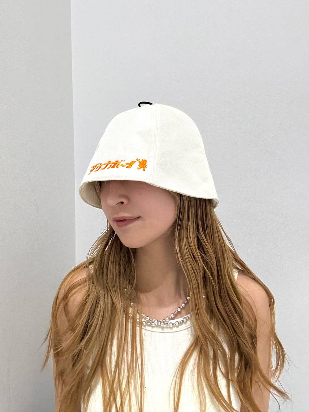 ホワイト系のハット、ブラック系のハットを着用したレディースの春コーディネートの3枚目の写真