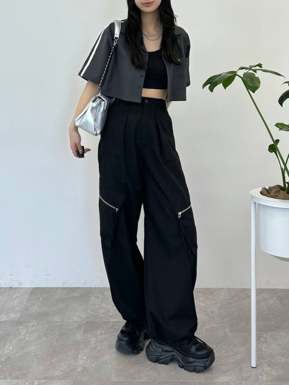 シルバー系のショルダーバッグ、ブラック系のスニーカー、ブラック系のカーゴパンツを着用したレディースの春コーディネートの4枚目の写真