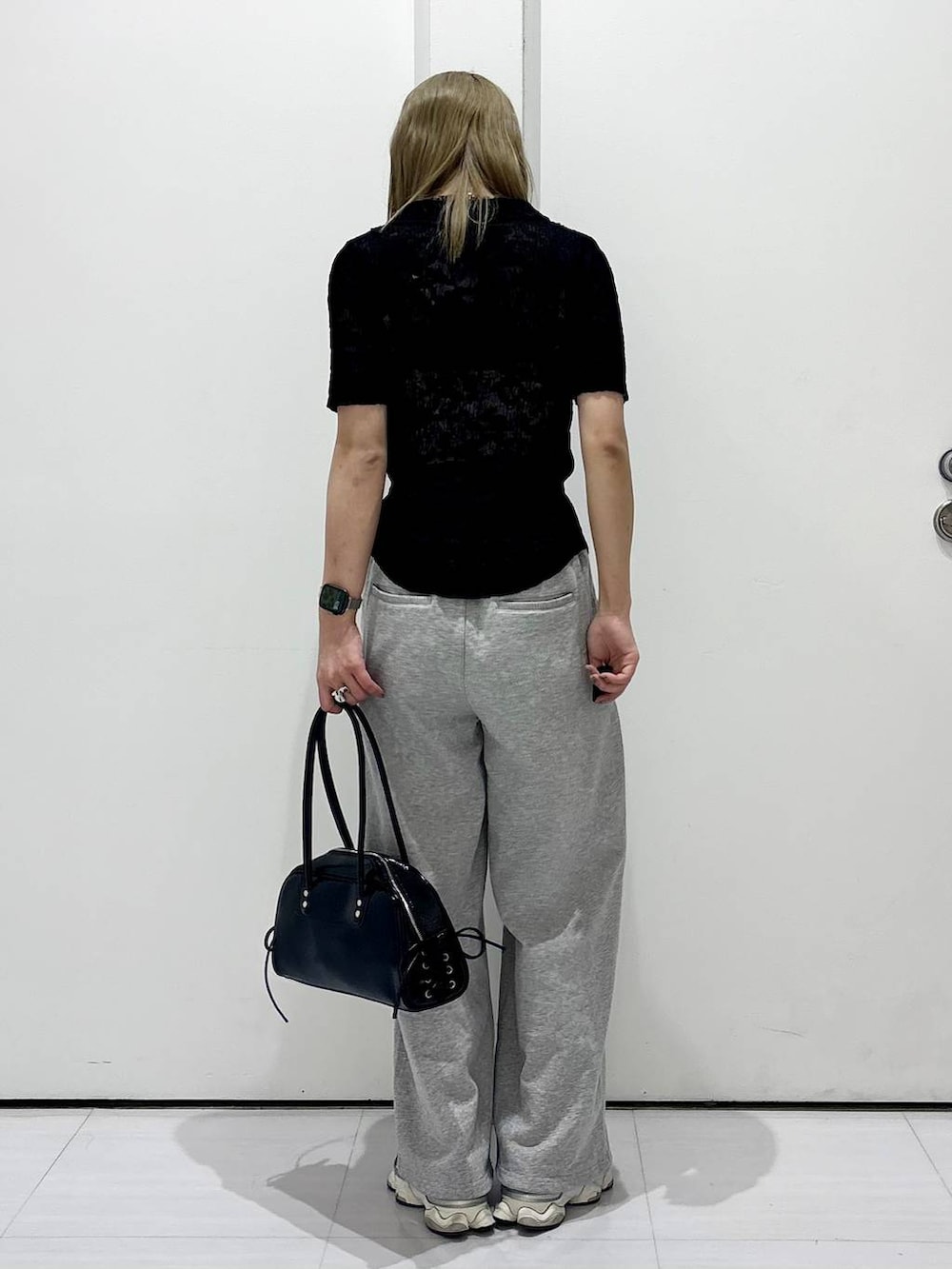 ブラック系のショルダーバッグ、ブラック系のシャツ/ブラウス、グレー系のスウェットパンツを着用したレディースの春コーディネートの7枚目の写真