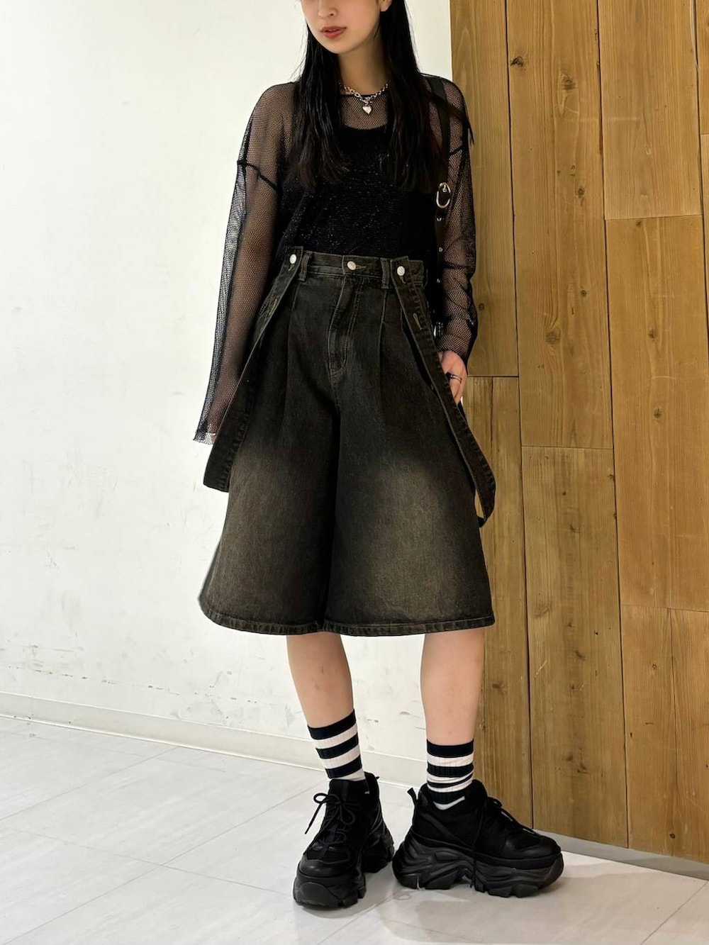 ブラック系のスニーカー、ブラック系のTシャツ/カットソー、ブラック系のデニムパンツを着用したレディースの春コーディネートの2枚目の写真