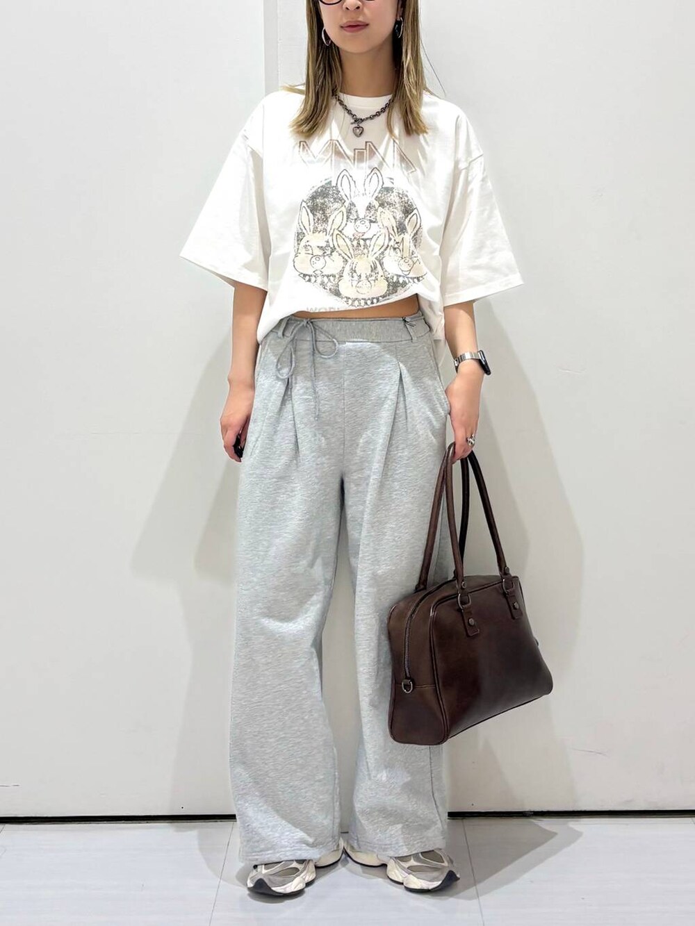ブラウン系のボストンバッグ、ホワイト系のTシャツ/カットソー、グレー系のスウェットパンツを着用したレディースの春コーディネートの5枚目の写真