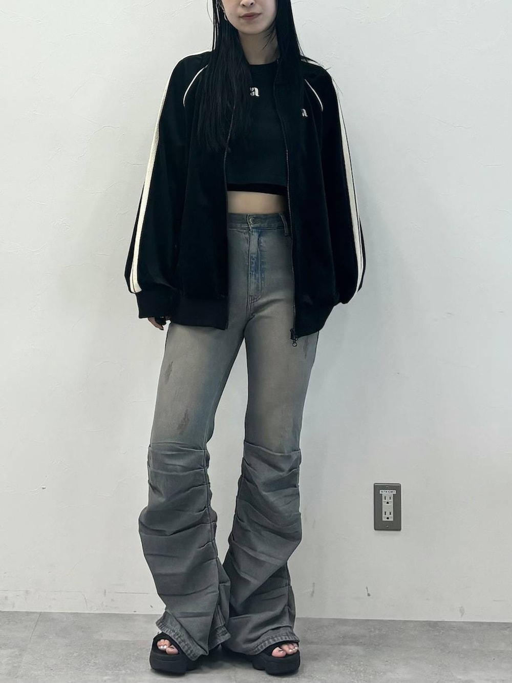 ブルー系のデニムパンツ、ブラック系のジャージを着用したレディースの秋コーディネートの2枚目の写真