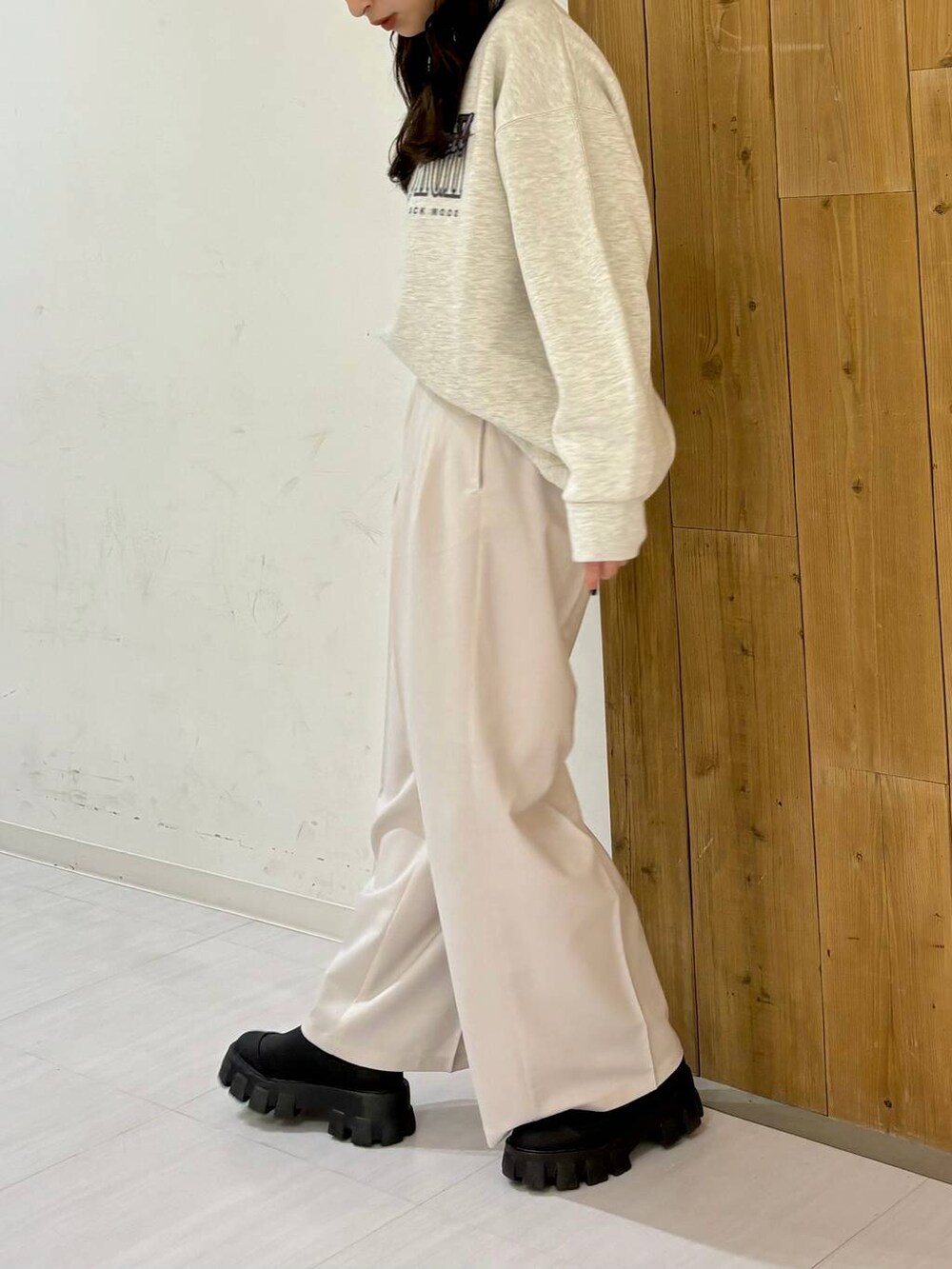 ブラック系のブーツ、ベージュ系のスラックス、ベージュ系のスウェットを着用したレディースの冬コーディネートの4枚目の写真