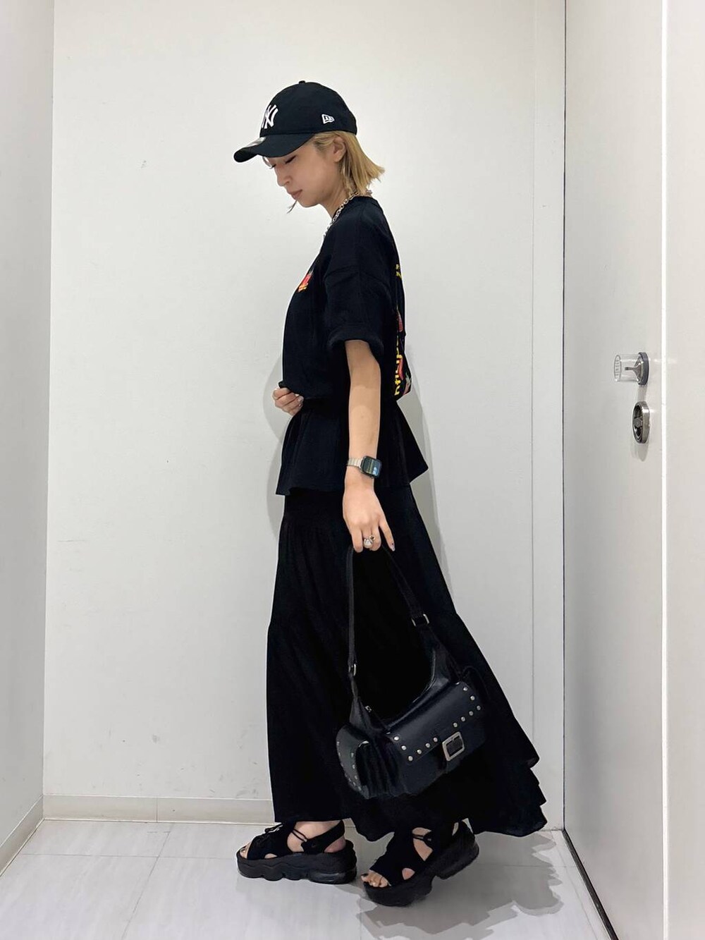 ブラック系のTシャツ/カットソー、ブラック系のスカート、ブラック系のショルダーバッグを着用したレディースの夏コーディネートの4枚目の写真