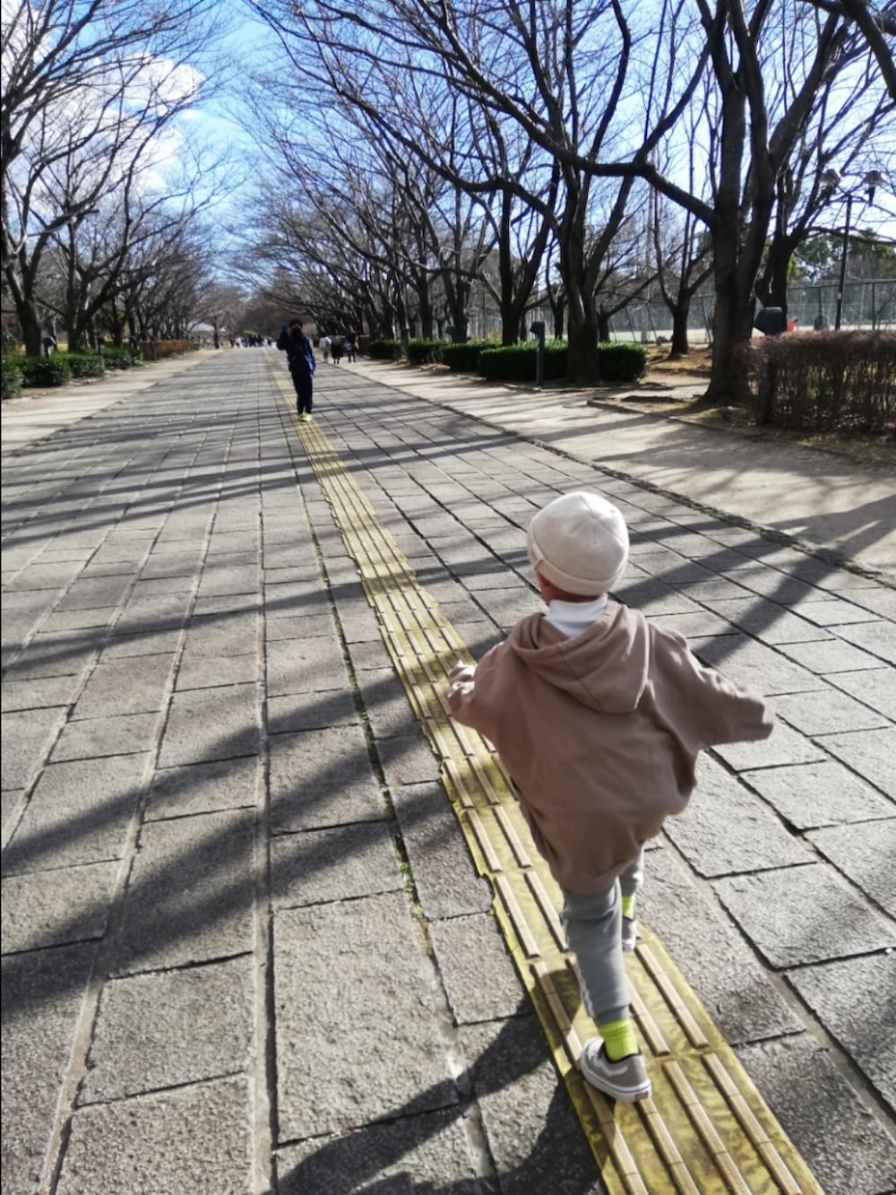 ベージュ系のパーカー、グリーン系のその他パンツ、ベージュ系のスニーカーを着用したキッズの冬コーディネートの4枚目の写真