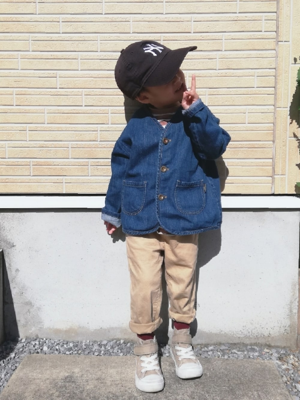 ベージュ系のTシャツ/カットソー、ブルー系のデニムジャケット、ベージュ系のその他パンツを着用したキッズの秋コーディネートの2枚目の写真