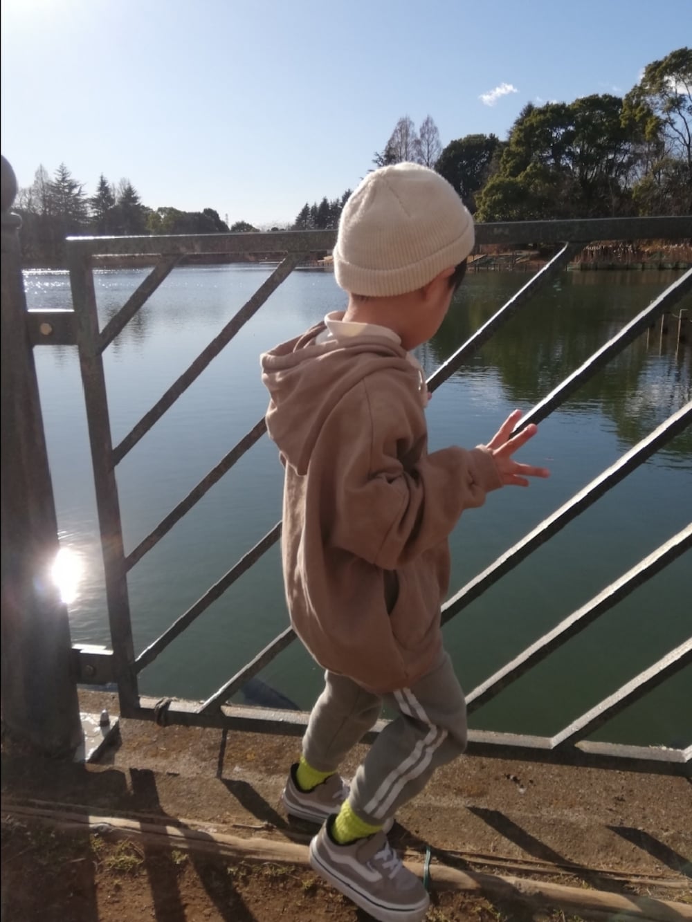 ベージュ系のパーカー、グリーン系のその他パンツ、ベージュ系のスニーカーを着用したキッズの冬コーディネートの3枚目の写真