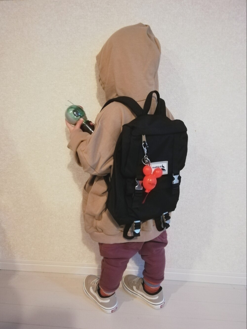 ベージュ系のパーカー、レッド系のその他パンツ、ベージュ系のスニーカーを着用したキッズの冬コーディネートの3枚目の写真