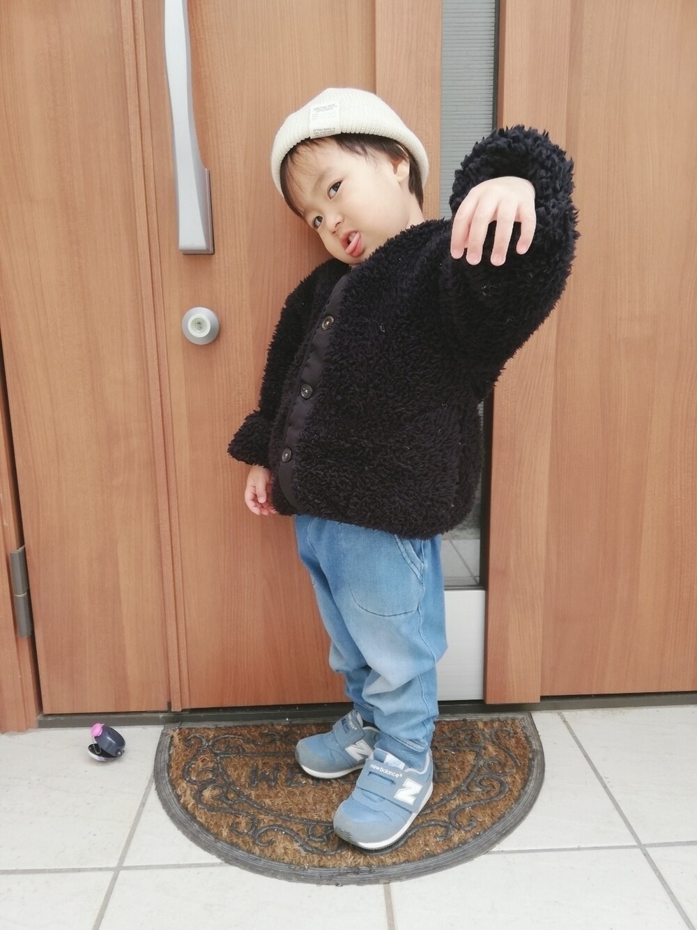 ブラック系のブルゾン、ブルー系のデニムパンツ、ブルー系のスニーカーを着用したキッズの春コーディネートの4枚目の写真