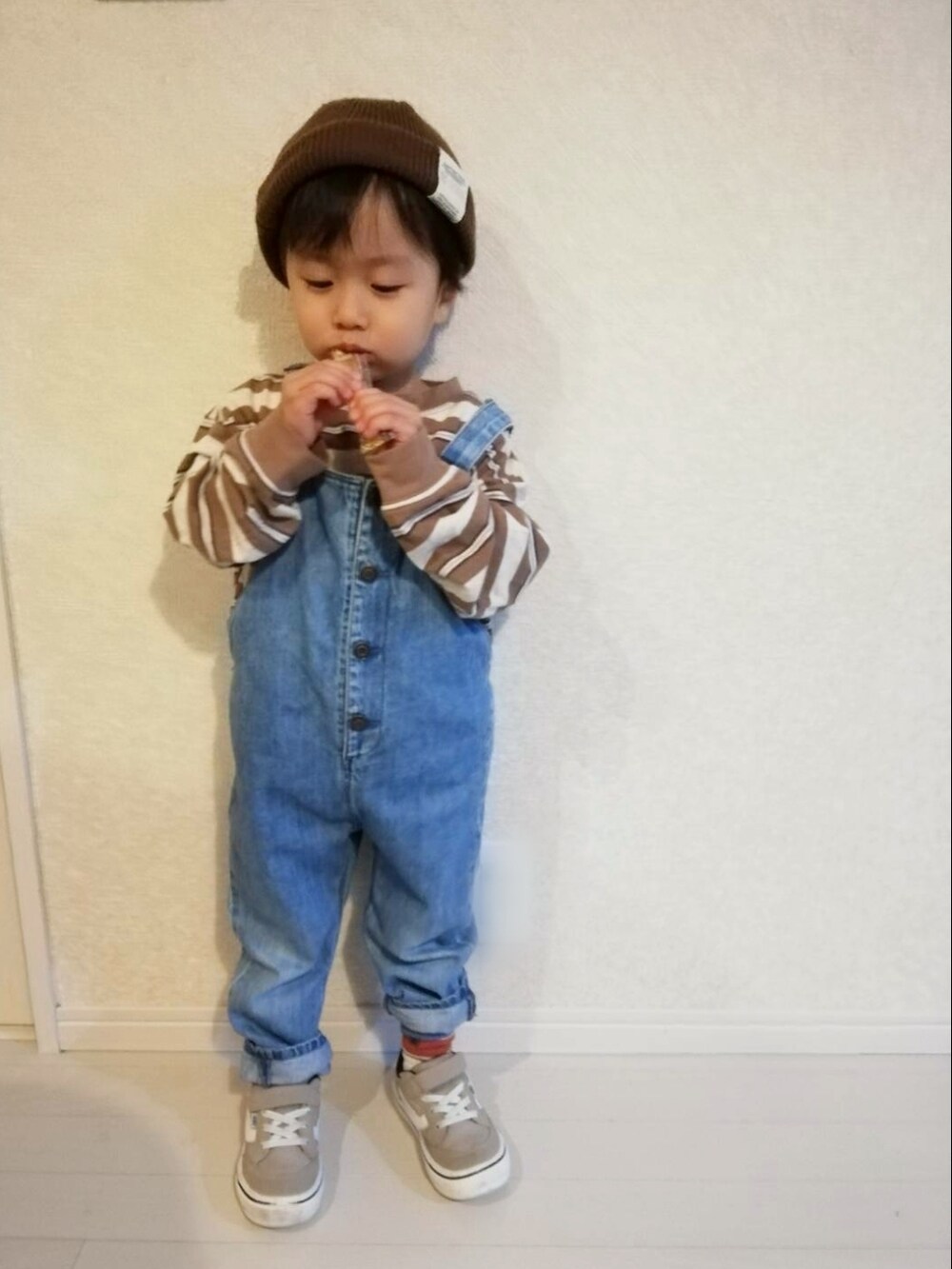 ベージュ系のTシャツ/カットソー、ブルー系のサロペット/オーバーオール、ベージュ系のスニーカーを着用したキッズの秋コーディネートの2枚目の写真