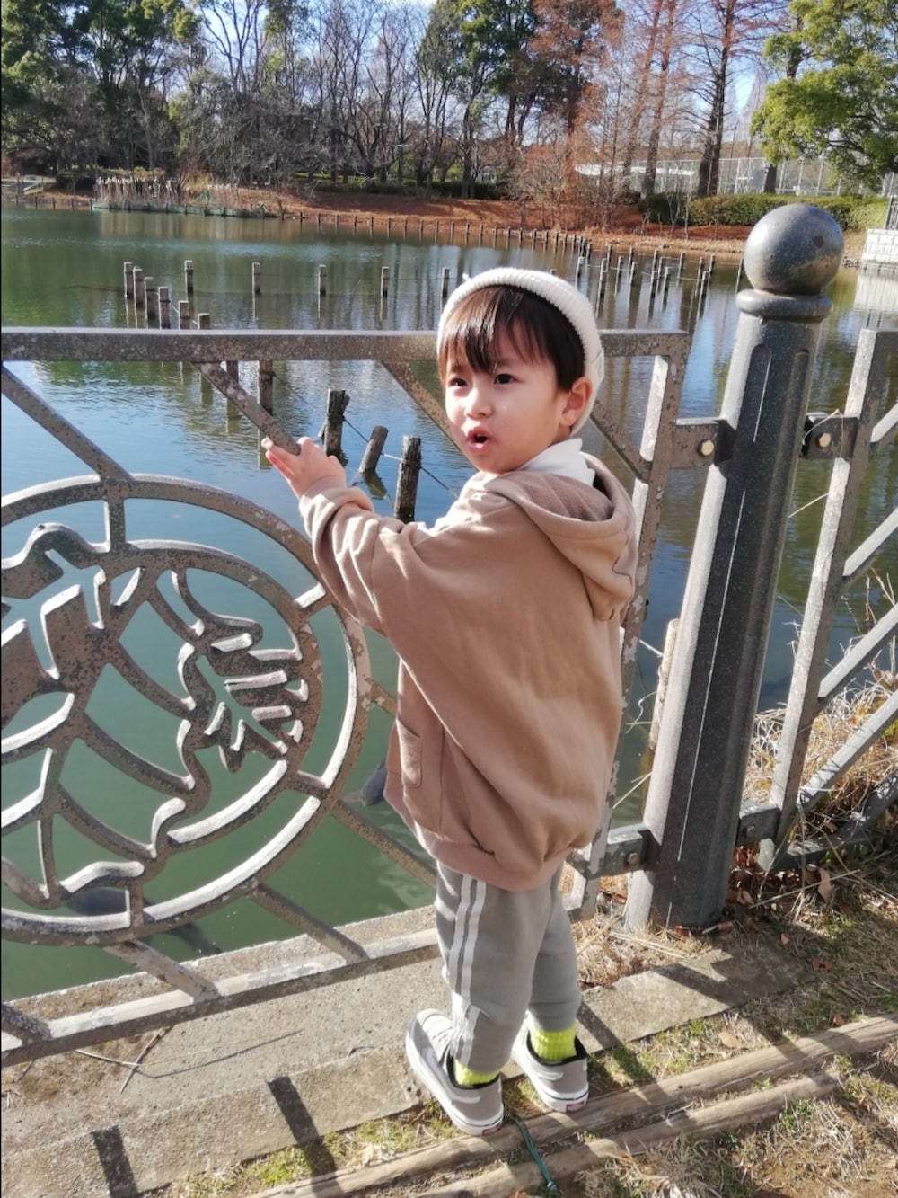 ベージュ系のパーカー、グリーン系のその他パンツ、ベージュ系のスニーカーを着用したキッズの冬コーディネートの2枚目の写真