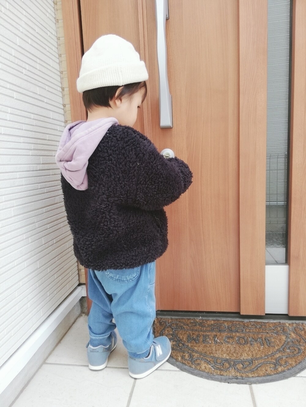 ブラック系のブルゾン、ブルー系のデニムパンツ、ブルー系のスニーカーを着用したキッズの春コーディネートの3枚目の写真