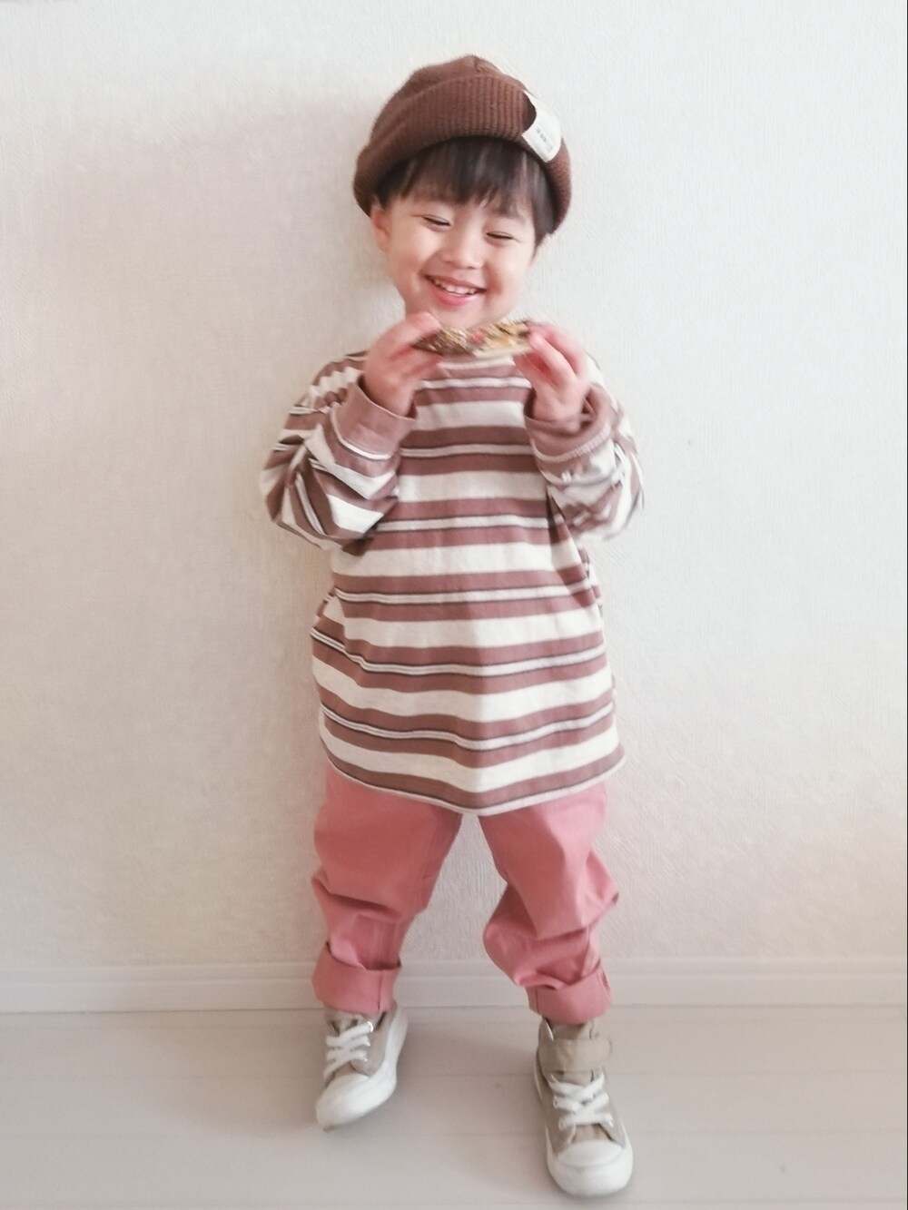ベージュ系のTシャツ/カットソー、ピンク系のチノパンツ、ベージュ系のスニーカーを着用したキッズの冬コーディネートの2枚目の写真
