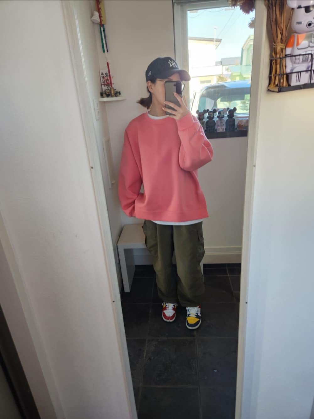 ピンク系のスウェット、ブルー系のデニムジャケット、ブラック系のバッグを着用したレディースの夏コーディネートの2枚目の写真