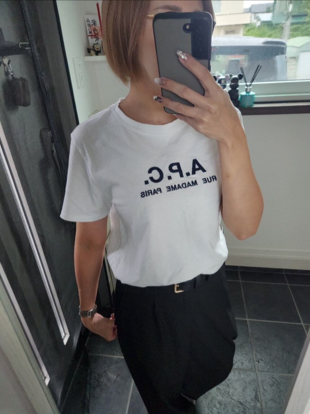 ホワイト系のTシャツ/カットソー、ブラック系のスラックス、その他のスニーカーを着用したレディースの夏コーディネートの2枚目の写真