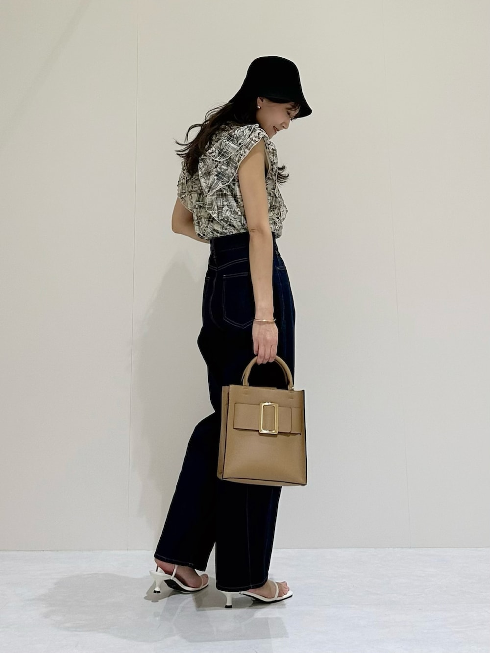 ブルー系のシャツ/ブラウス、ブルー系のデニムパンツ、ベージュ系のハンドバッグを着用したレディースの春コーディネートの2枚目の写真