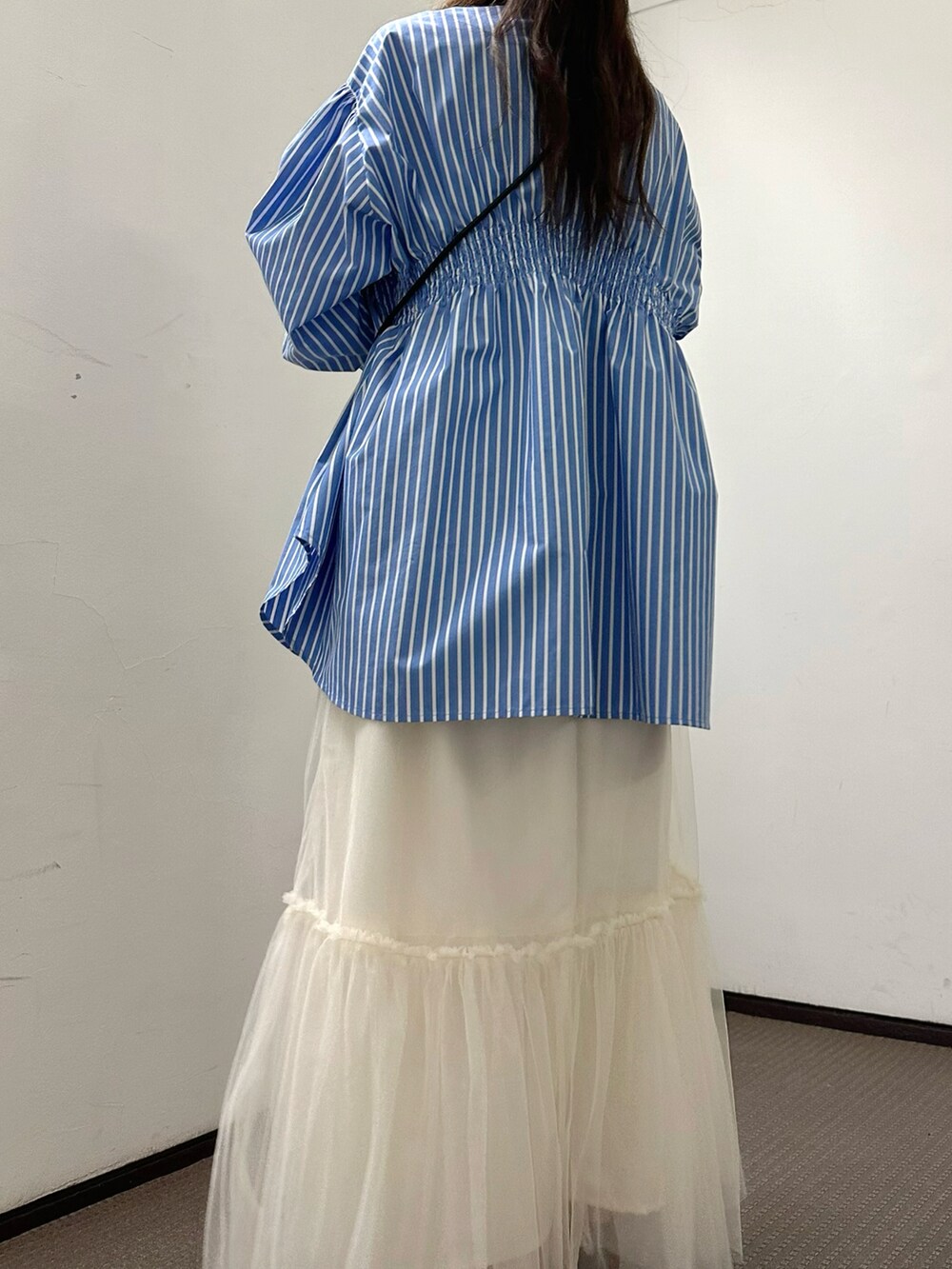 ブルー系のシャツ/ブラウス、ベージュ系のショルダーバッグ、グレー系のスカートを着用したレディースの春コーディネートの3枚目の写真