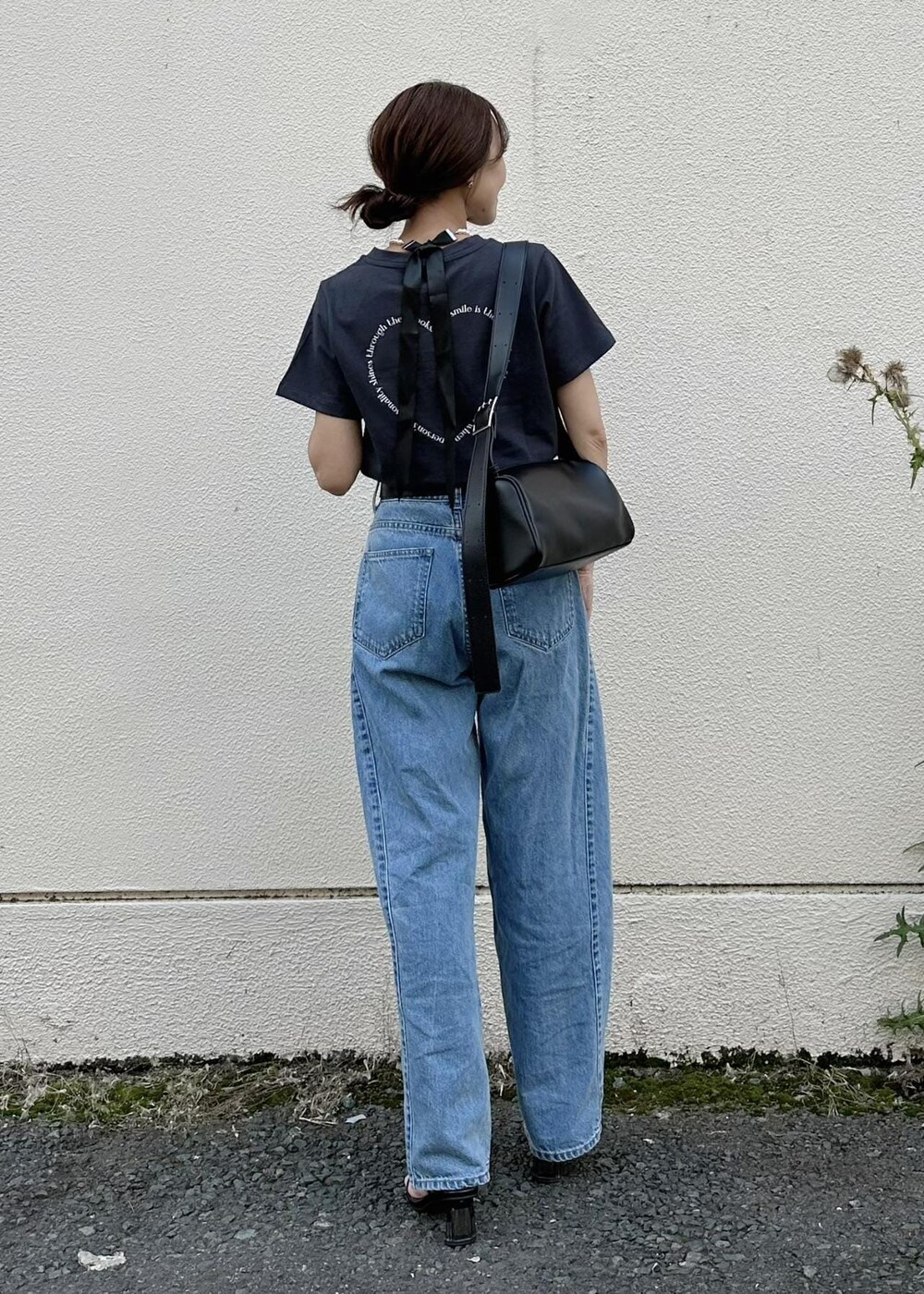 ブラック系のショルダーバッグ、ブルー系のデニムパンツ、ブラック系のTシャツ/カットソーを着用したレディースの夏コーディネートの4枚目の写真