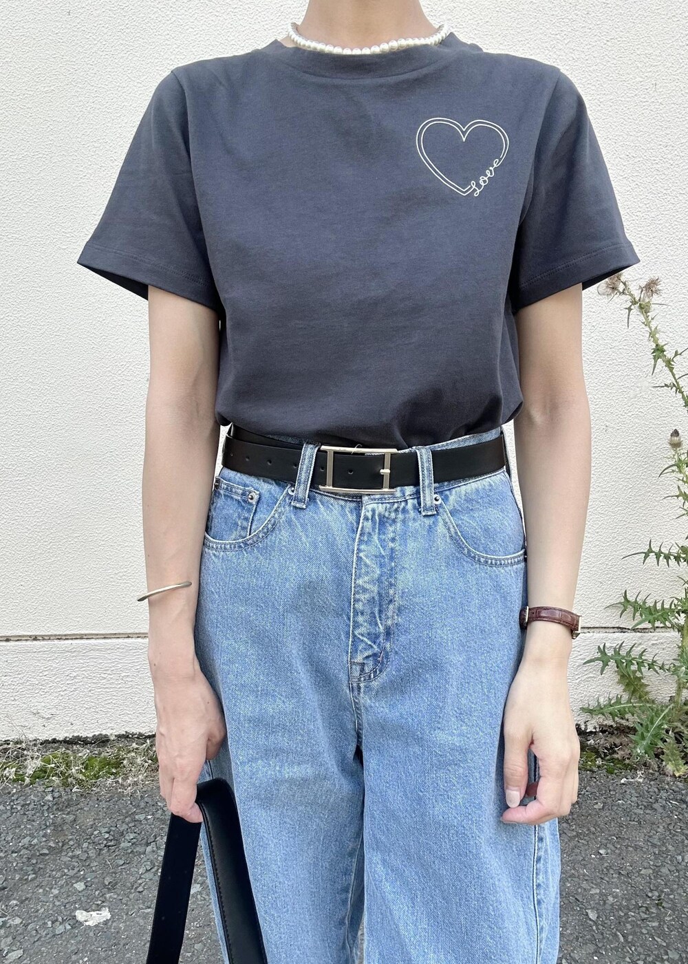 ブラック系のショルダーバッグ、ブルー系のデニムパンツ、ブラック系のTシャツ/カットソーを着用したレディースの夏コーディネートの5枚目の写真