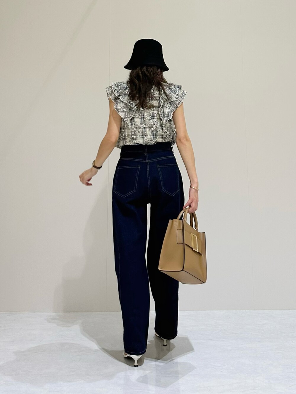 ブルー系のシャツ/ブラウス、ブルー系のデニムパンツ、ベージュ系のハンドバッグを着用したレディースの春コーディネートの3枚目の写真