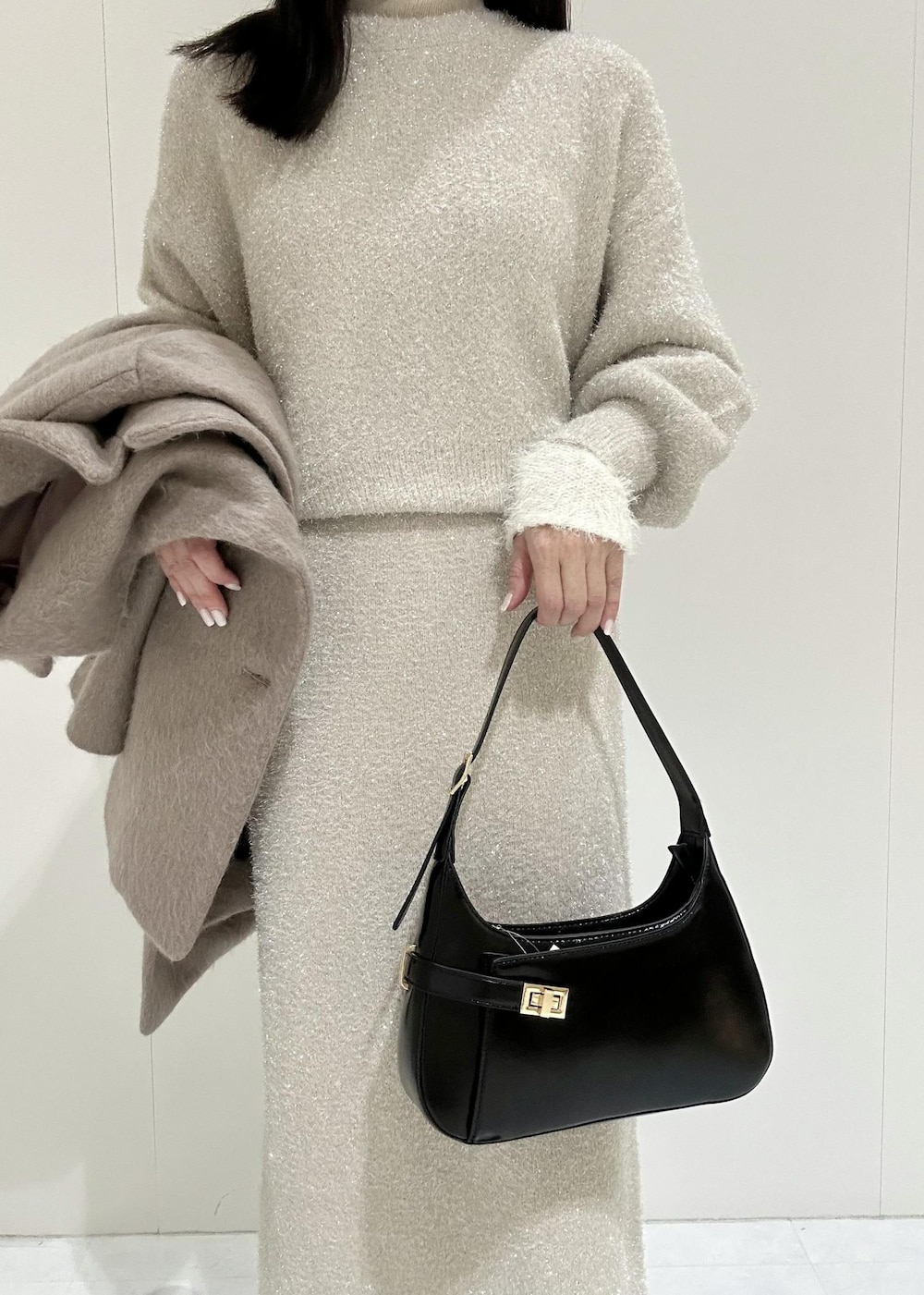 ベージュ系のスカート、ホワイト系のニット/セーター、ベージュ系のニット/セーターを着用したレディースの冬コーディネートの8枚目の写真