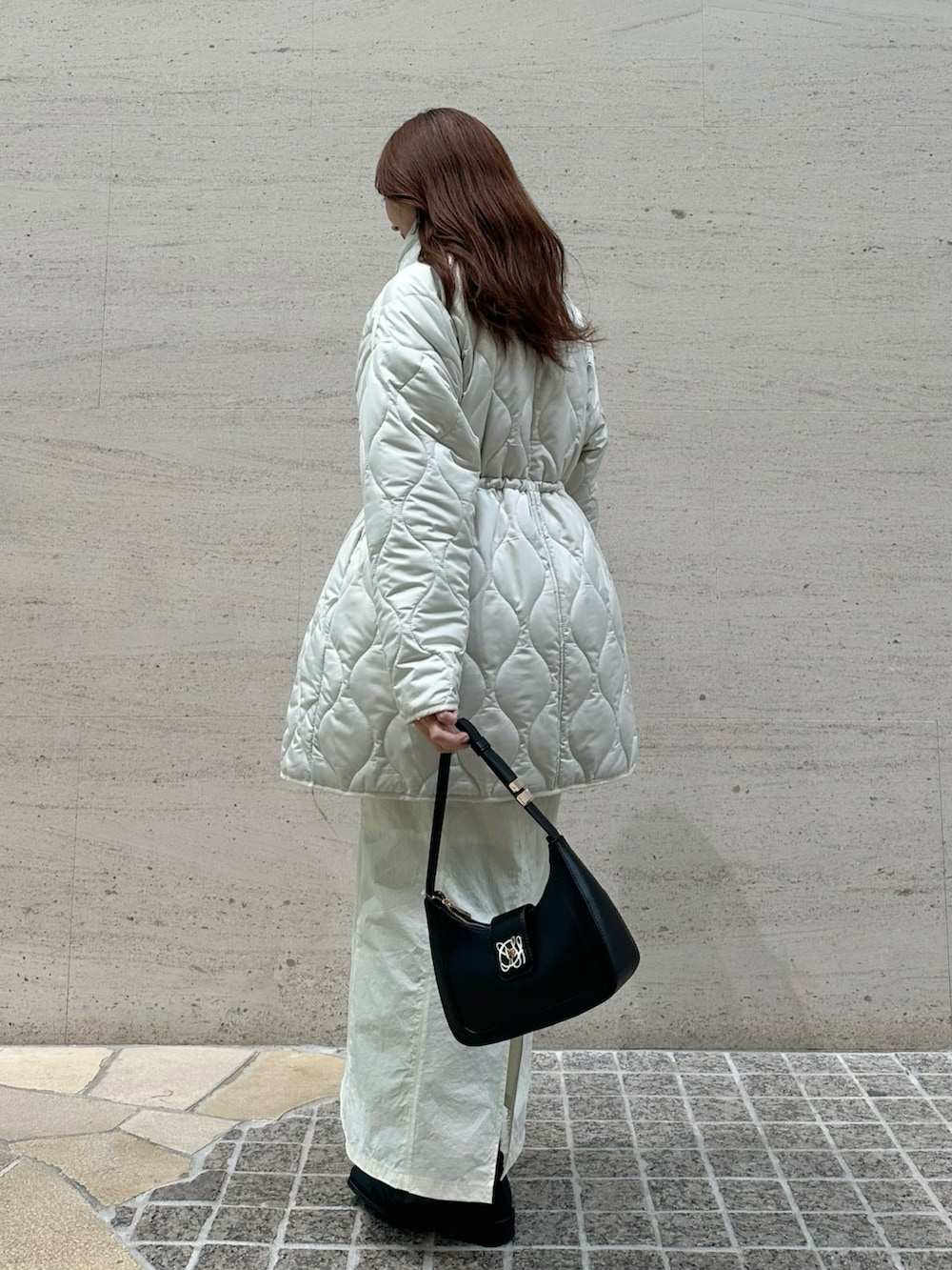 ホワイト系のブルゾン、ホワイト系のスカート、ブラック系のハンドバッグを着用したレディースの冬コーディネートの4枚目の写真