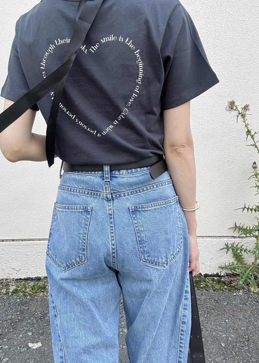 ブラック系のショルダーバッグ、ブルー系のデニムパンツ、ブラック系のTシャツ/カットソーを着用したレディースの夏コーディネートの7枚目の写真