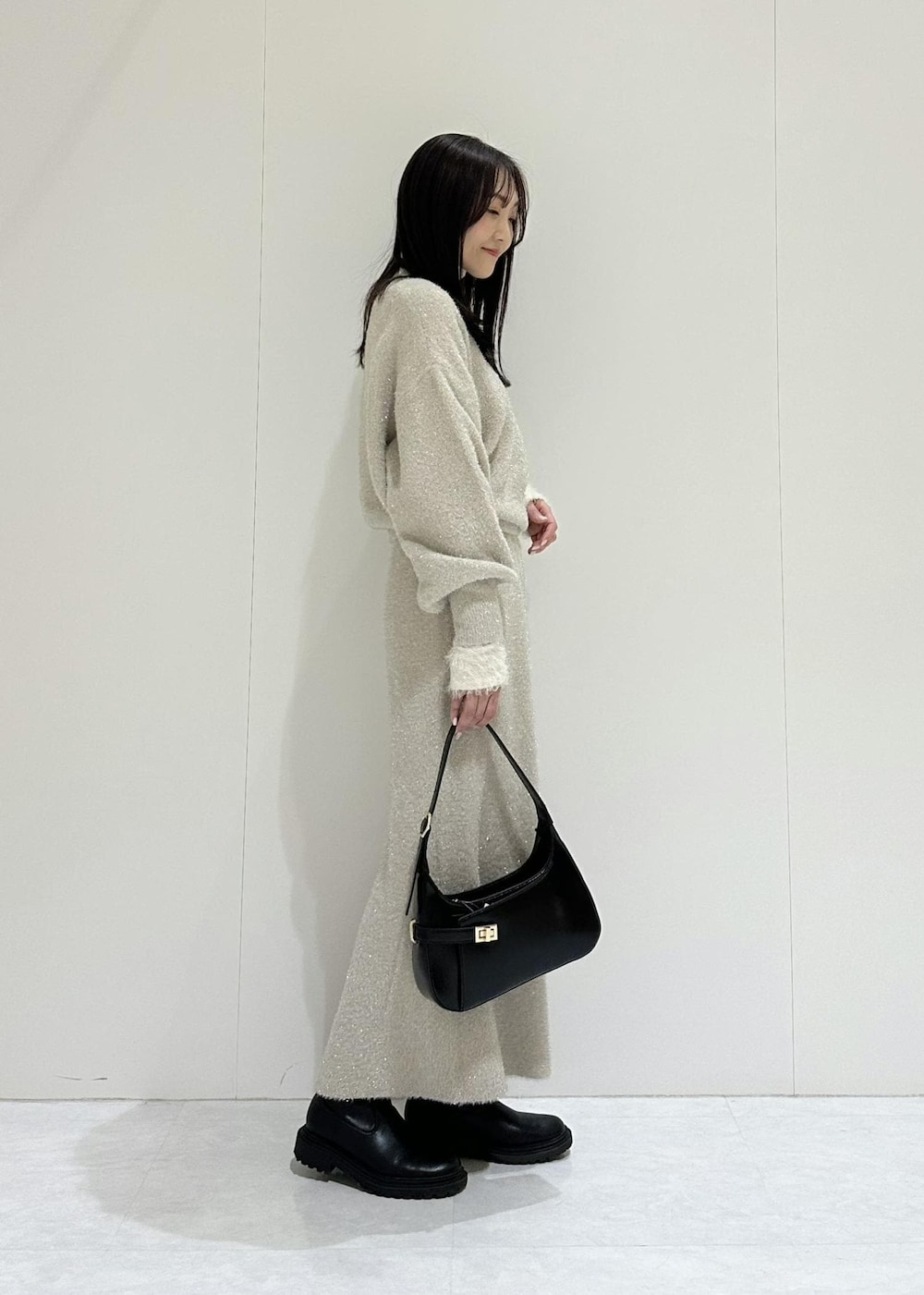 ベージュ系のスカート、ホワイト系のニット/セーター、ベージュ系のニット/セーターを着用したレディースの冬コーディネートの6枚目の写真