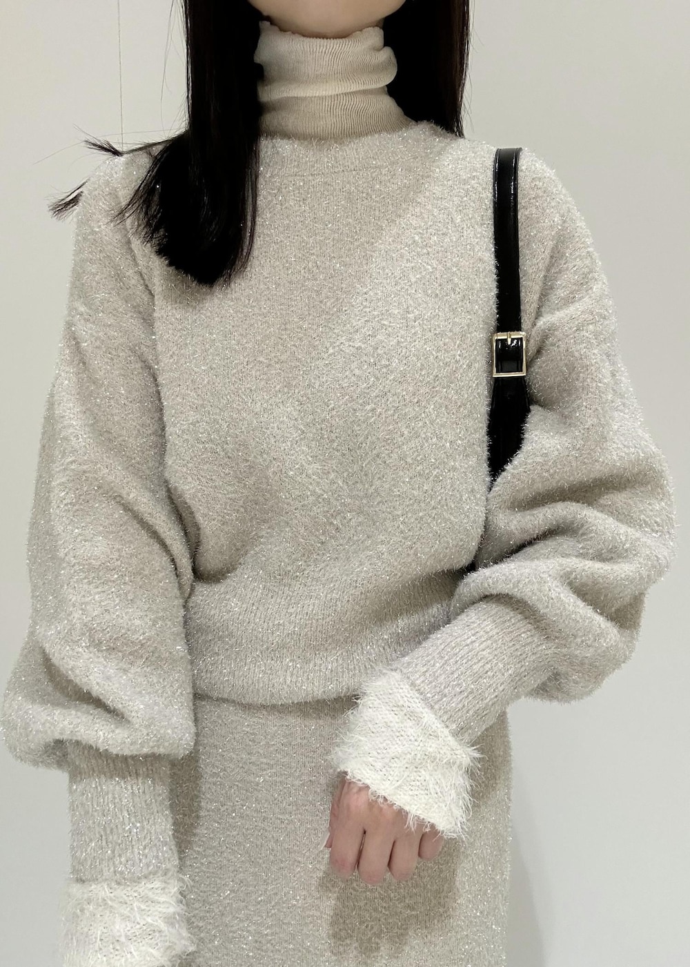 ベージュ系のスカート、ホワイト系のニット/セーター、ベージュ系のニット/セーターを着用したレディースの冬コーディネートの9枚目の写真