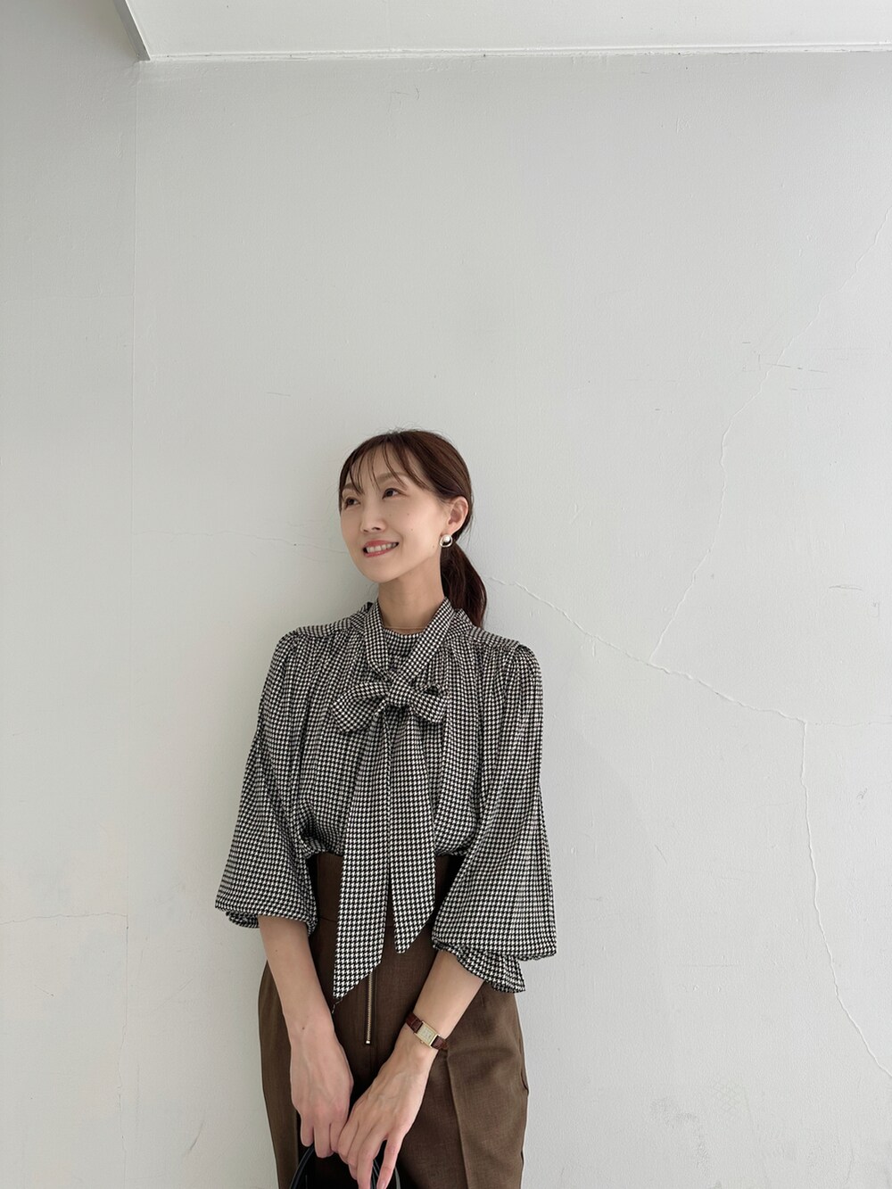 ブラウン系のシャツ/ブラウス、ブラウン系のスラックス、ブラック系のショルダーバッグを着用したレディースの夏コーディネートの4枚目の写真