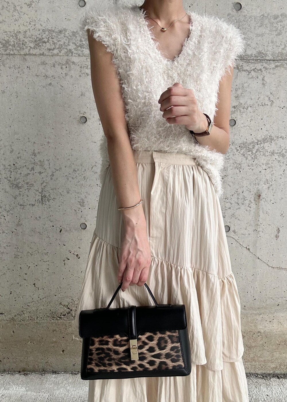 ブラック系のサンダル、ホワイト系のベスト、その他のショルダーバッグを着用したレディースの秋コーディネートの4枚目の写真