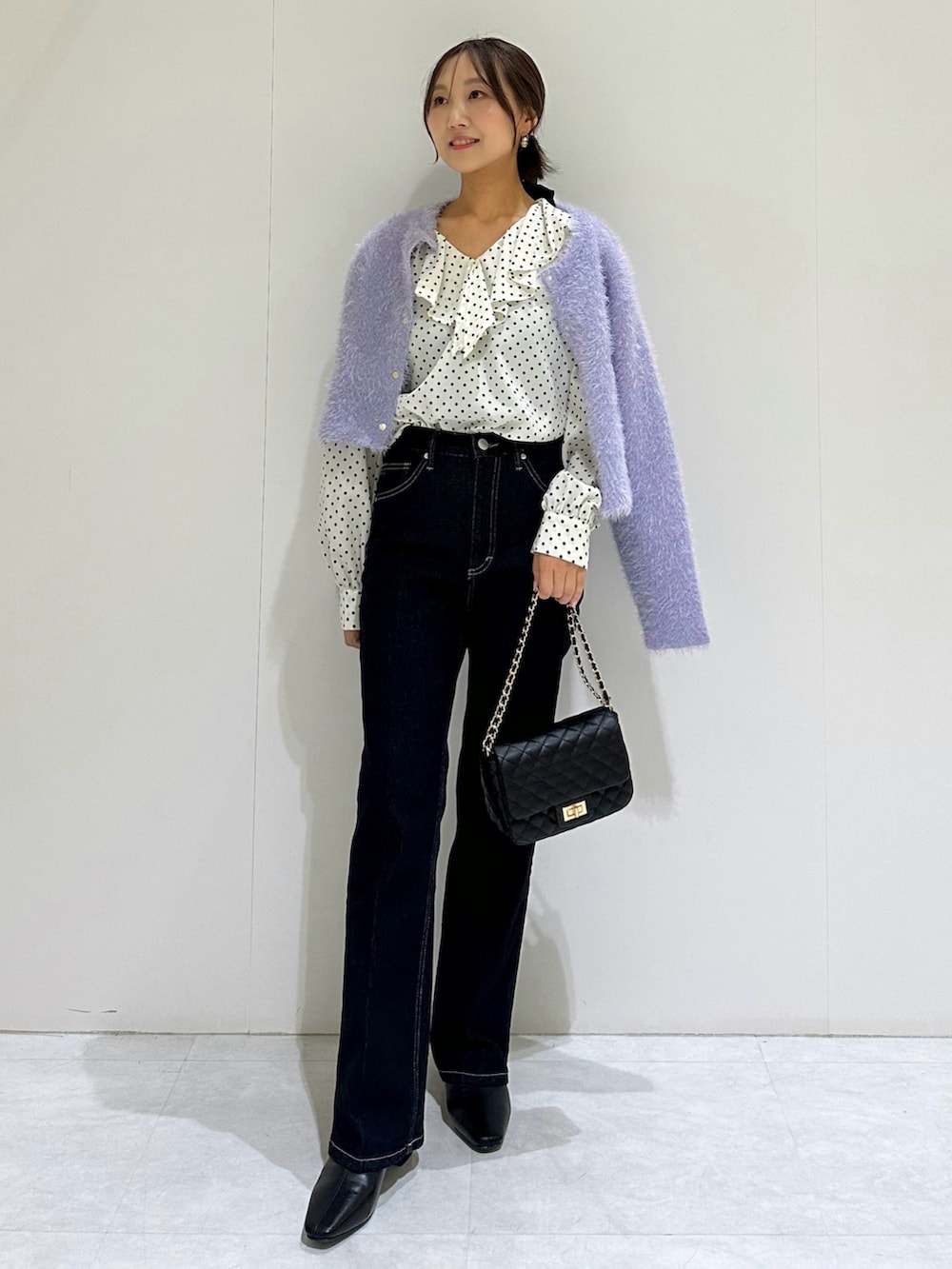 パープル系のカーディガン/ボレロ、ホワイト系のシャツ/ブラウス、ブルー系のデニムパンツを着用したレディースの秋コーディネートの2枚目の写真