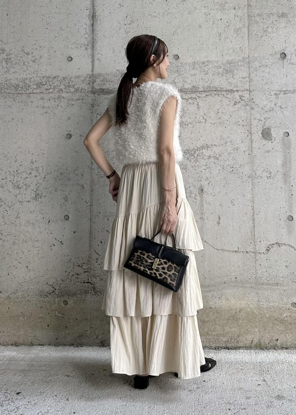 ブラック系のサンダル、ホワイト系のベスト、その他のショルダーバッグを着用したレディースの秋コーディネートの3枚目の写真