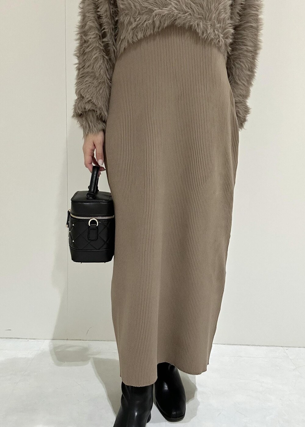 ブラック系のブーツ、ブラウン系のワンピース、ブラック系のハンドバッグを着用したレディースの秋コーディネートの6枚目の写真