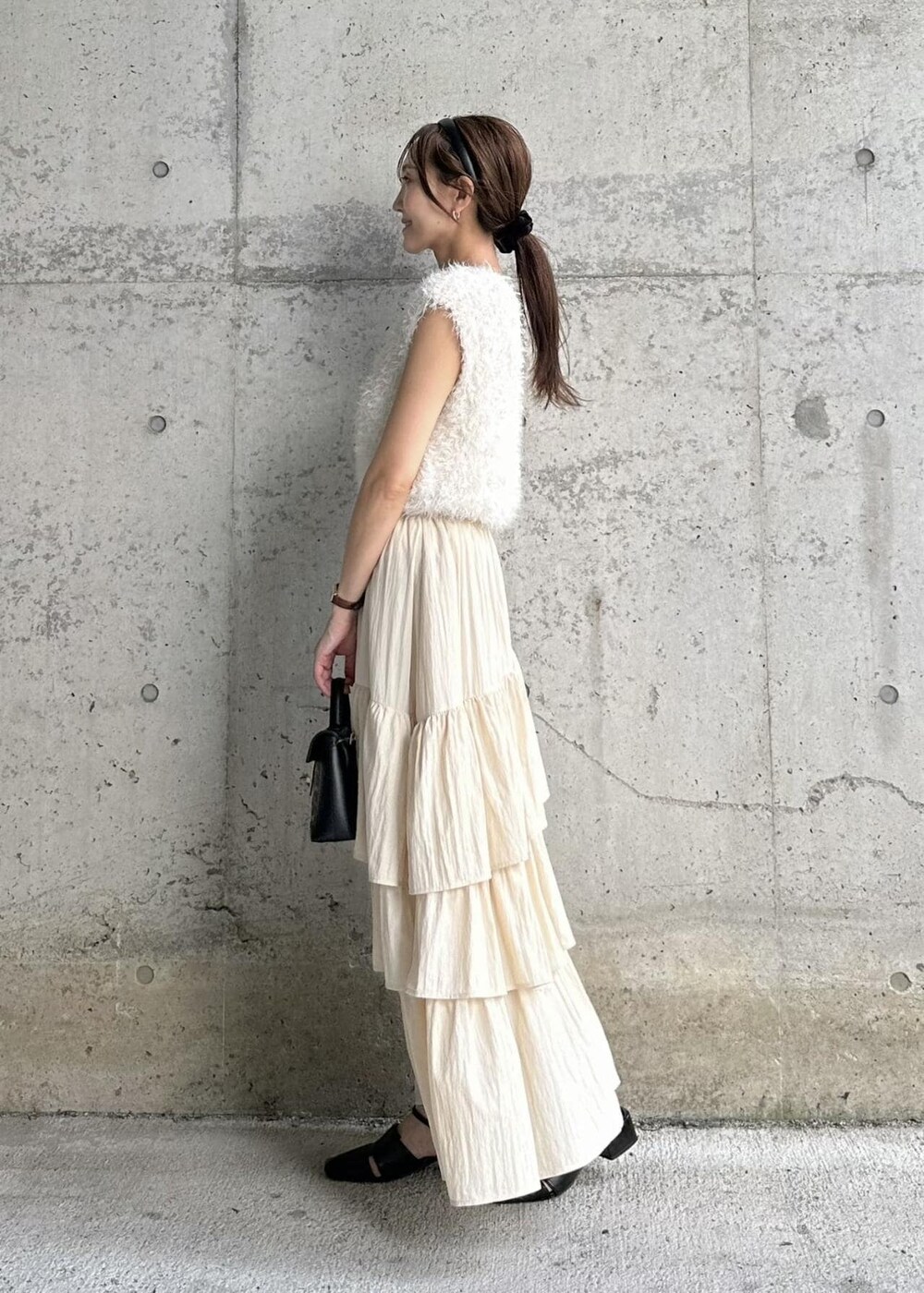 ブラック系のサンダル、ホワイト系のベスト、その他のショルダーバッグを着用したレディースの秋コーディネートの2枚目の写真