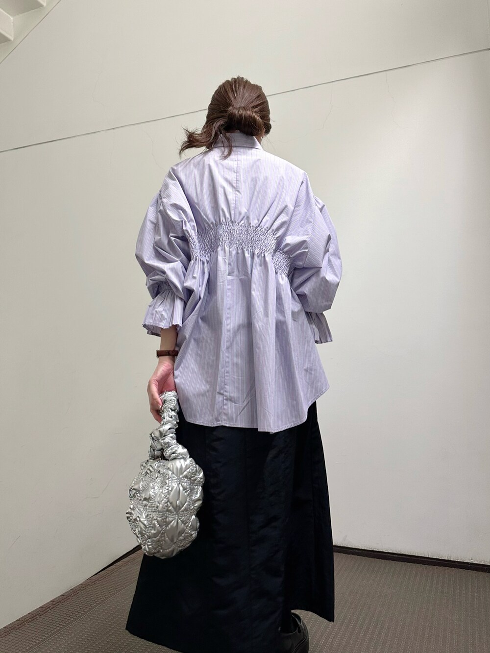 ブルー系のシャツ/ブラウス、グリーン系のショルダーバッグ、ブラック系のスカートを着用したレディースの春コーディネートの2枚目の写真