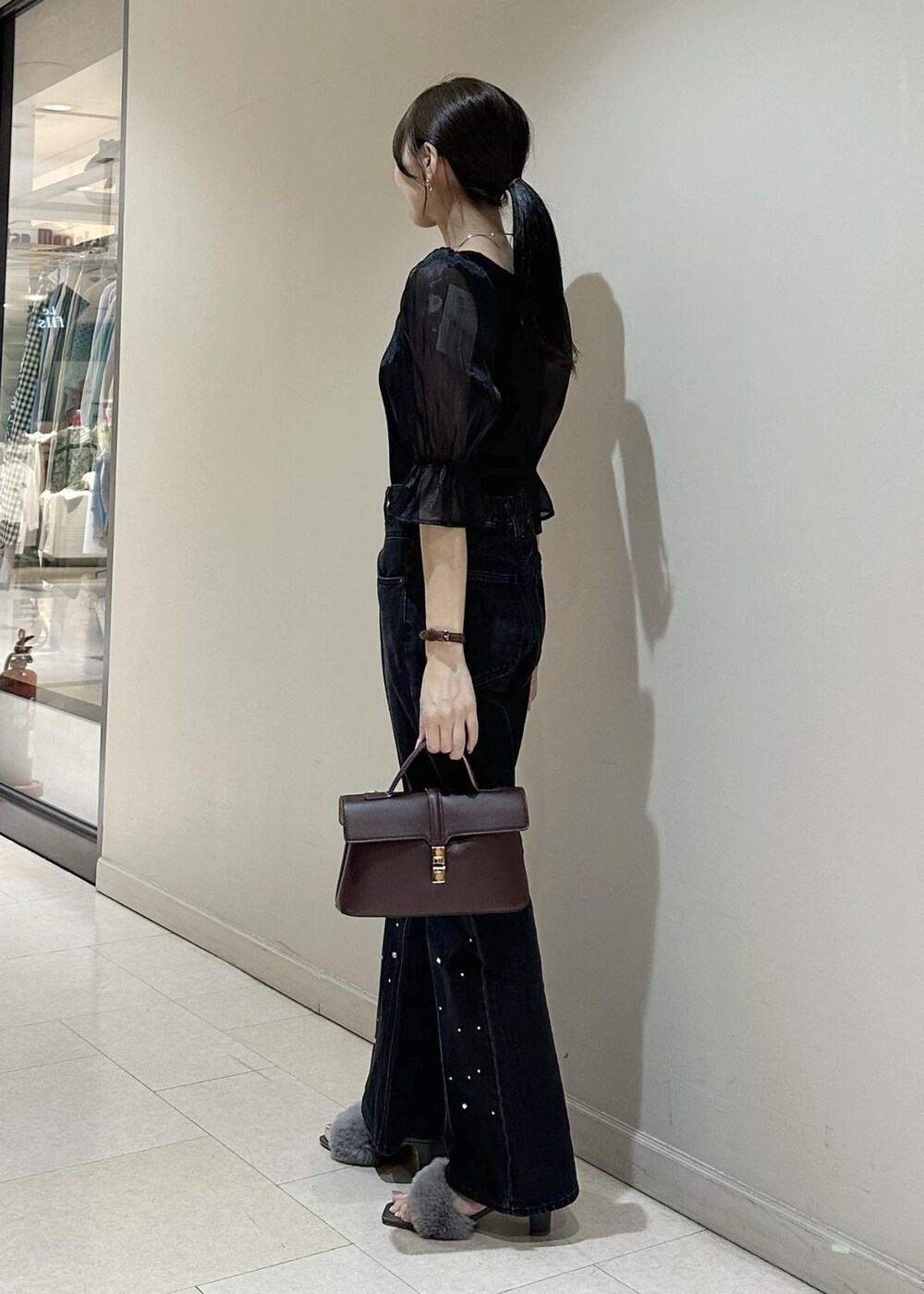 ブラック系のデニムパンツ、ブラック系のTシャツ/カットソー、ブラウン系のショルダーバッグを着用したレディースの夏コーディネートの3枚目の写真