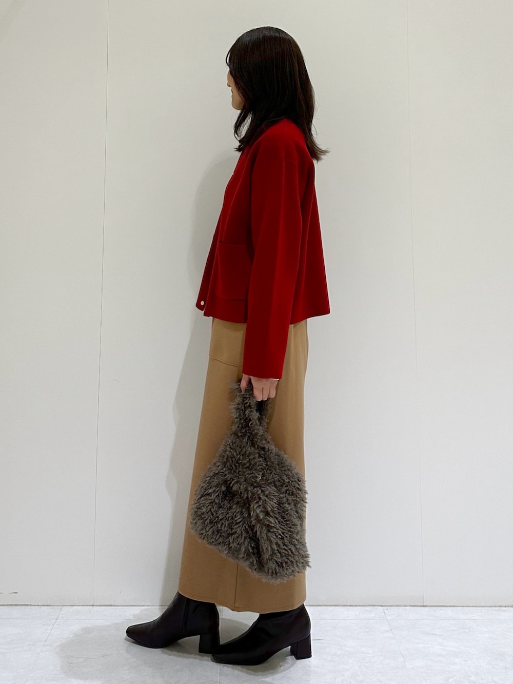 ホワイト系のTシャツ/カットソー、レッド系のカーディガン/ボレロ、イエロー系のスカートを着用したレディースの秋コーディネートの2枚目の写真