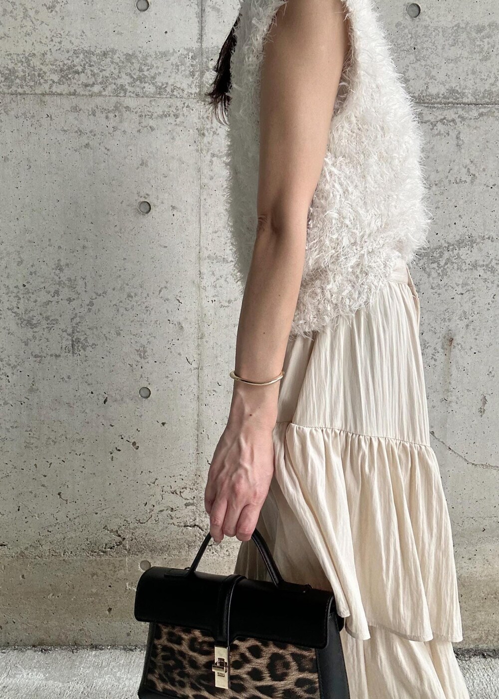 ブラック系のサンダル、ホワイト系のベスト、その他のショルダーバッグを着用したレディースの秋コーディネートの5枚目の写真