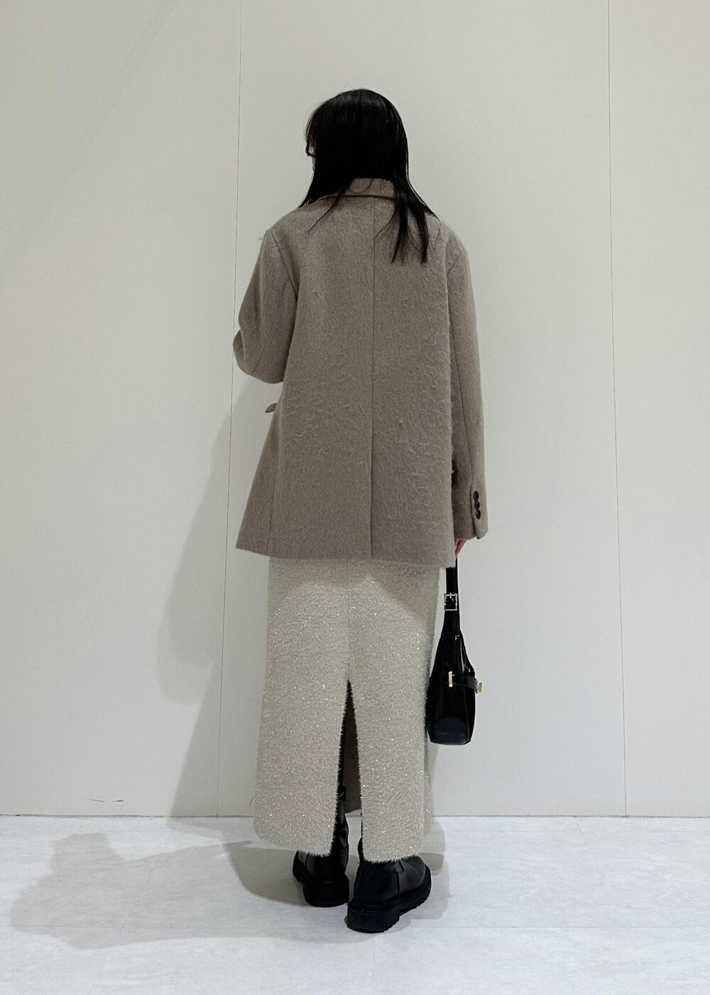 ベージュ系のスカート、ホワイト系のニット/セーター、ベージュ系のニット/セーターを着用したレディースの冬コーディネートの4枚目の写真