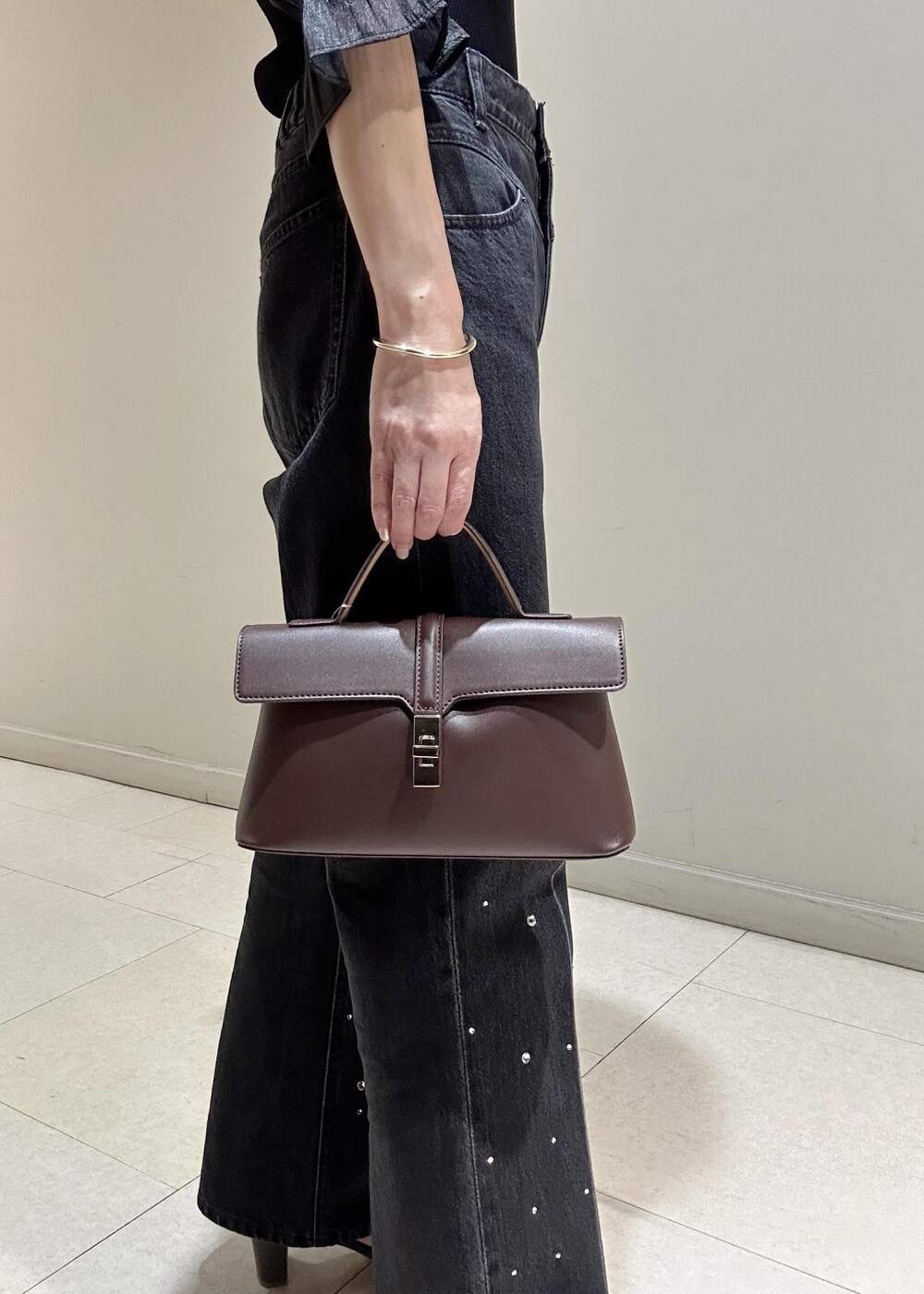 ブラック系のデニムパンツ、ブラック系のTシャツ/カットソー、ブラウン系のショルダーバッグを着用したレディースの夏コーディネートの9枚目の写真