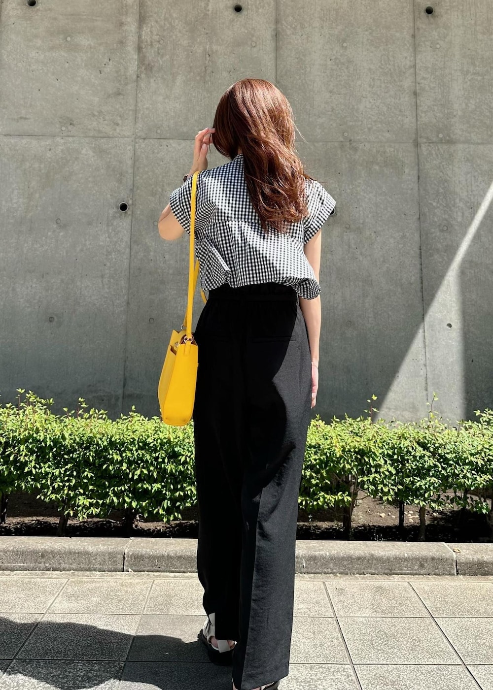 ホワイト系のサンダル、イエロー系のショルダーバッグ、ブラック系のスラックスを着用したレディースの秋コーディネートの4枚目の写真