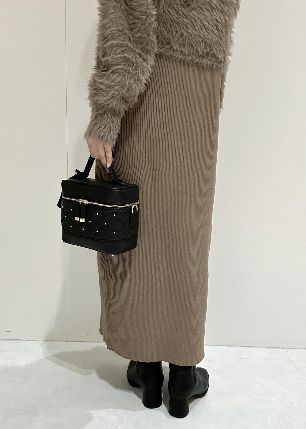 ブラック系のブーツ、ブラウン系のワンピース、ブラック系のハンドバッグを着用したレディースの秋コーディネートの8枚目の写真