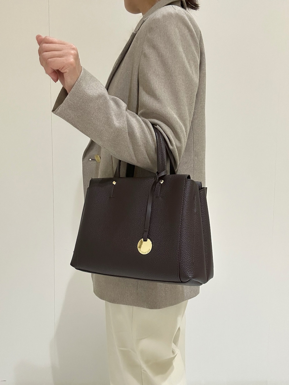 ホワイト系のニット/セーター、ベージュ系のテーラードジャケット、ホワイト系のその他パンツを着用したレディースの秋コーディネートの5枚目の写真