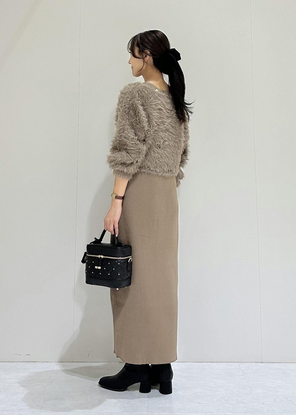 ブラック系のブーツ、ブラウン系のワンピース、ブラック系のハンドバッグを着用したレディースの秋コーディネートの4枚目の写真