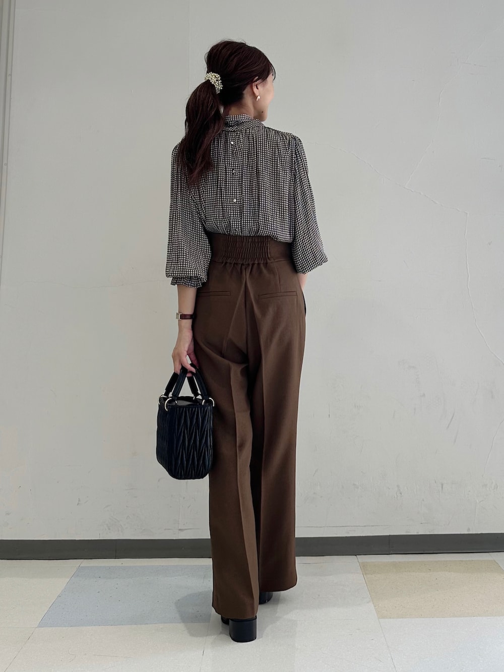 ブラウン系のシャツ/ブラウス、ブラウン系のスラックス、ブラック系のショルダーバッグを着用したレディースの夏コーディネートの2枚目の写真