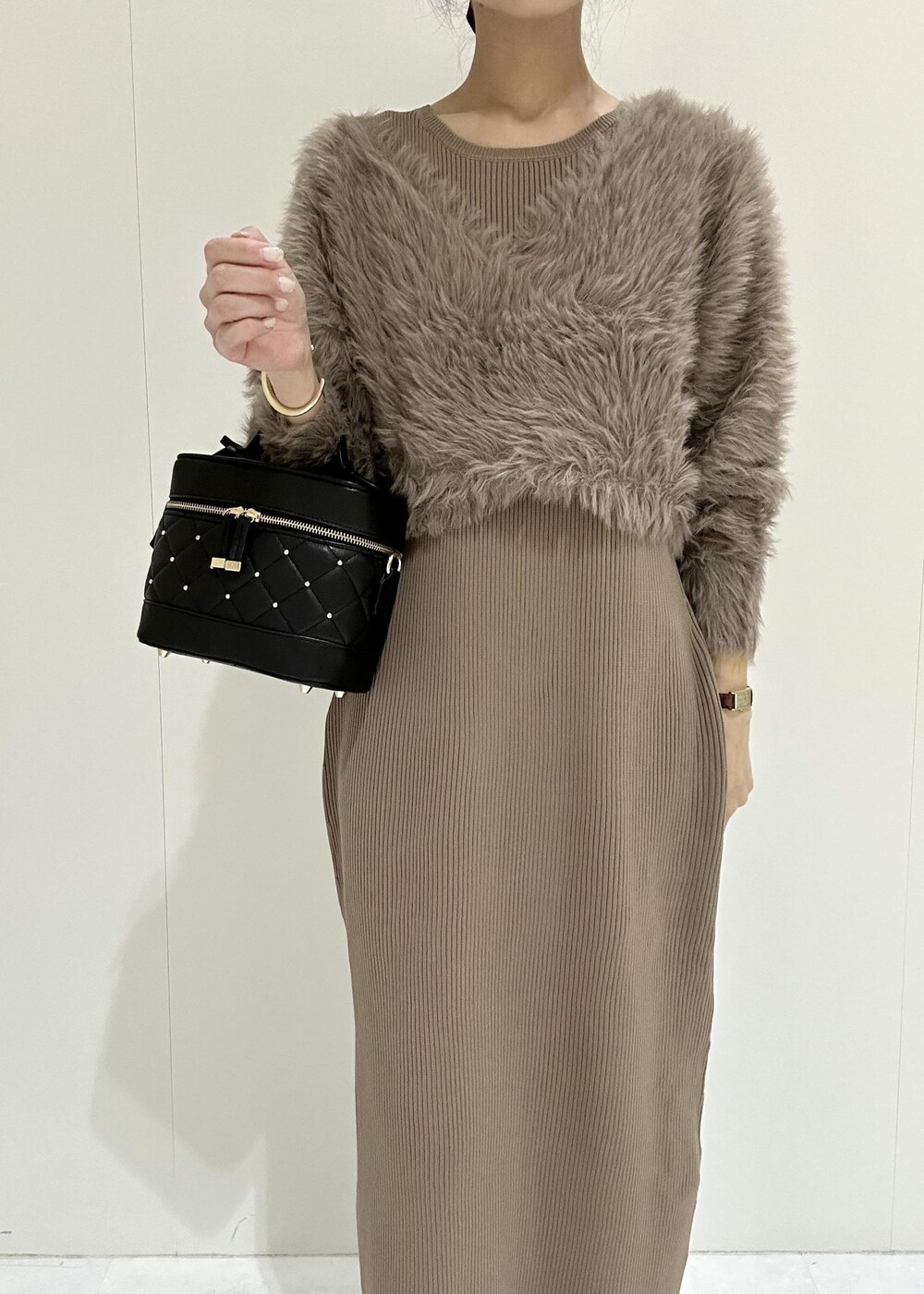 ブラック系のブーツ、ブラウン系のワンピース、ブラック系のハンドバッグを着用したレディースの秋コーディネートの5枚目の写真