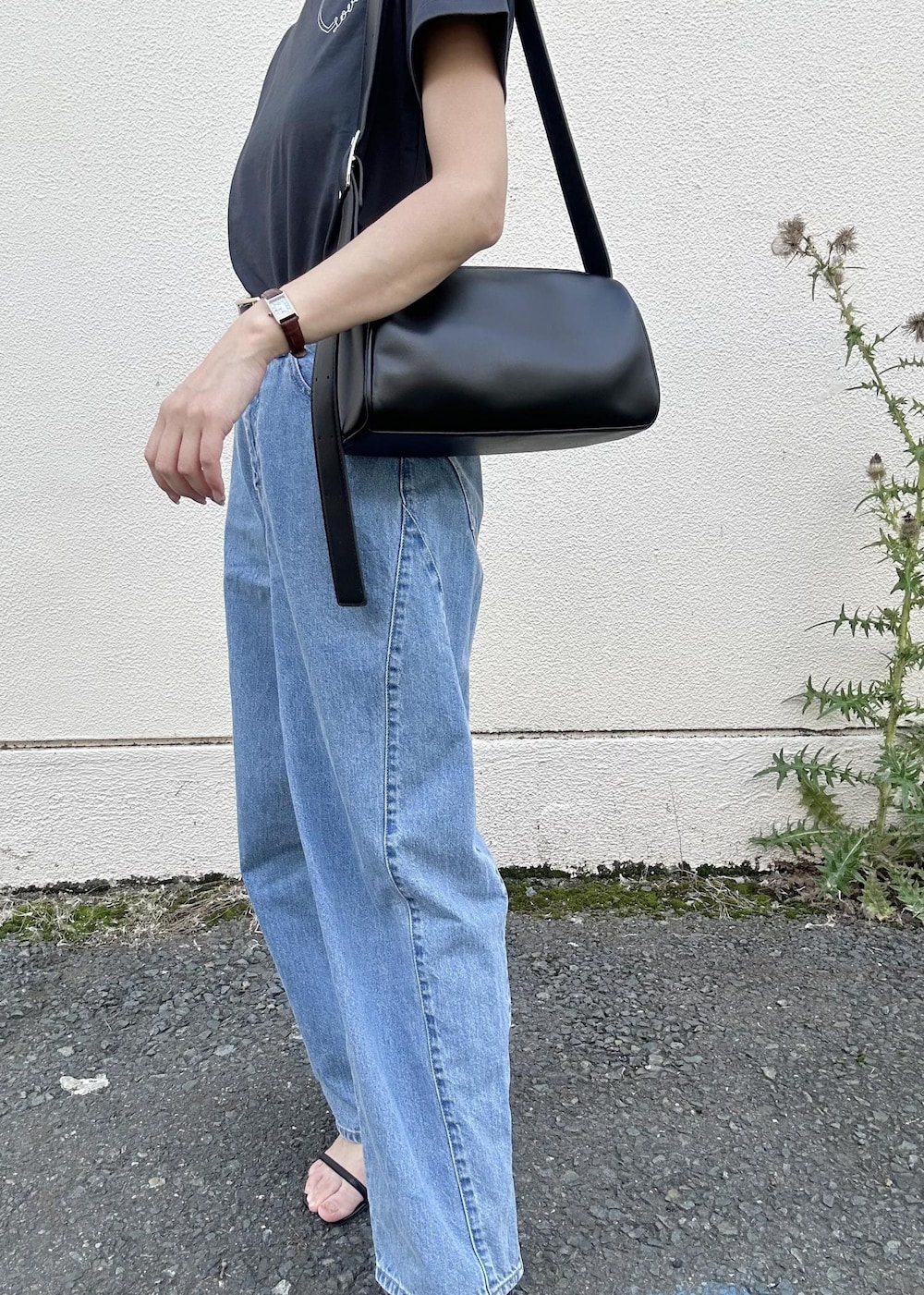 ブラック系のショルダーバッグ、ブルー系のデニムパンツ、ブラック系のTシャツ/カットソーを着用したレディースの夏コーディネートの8枚目の写真