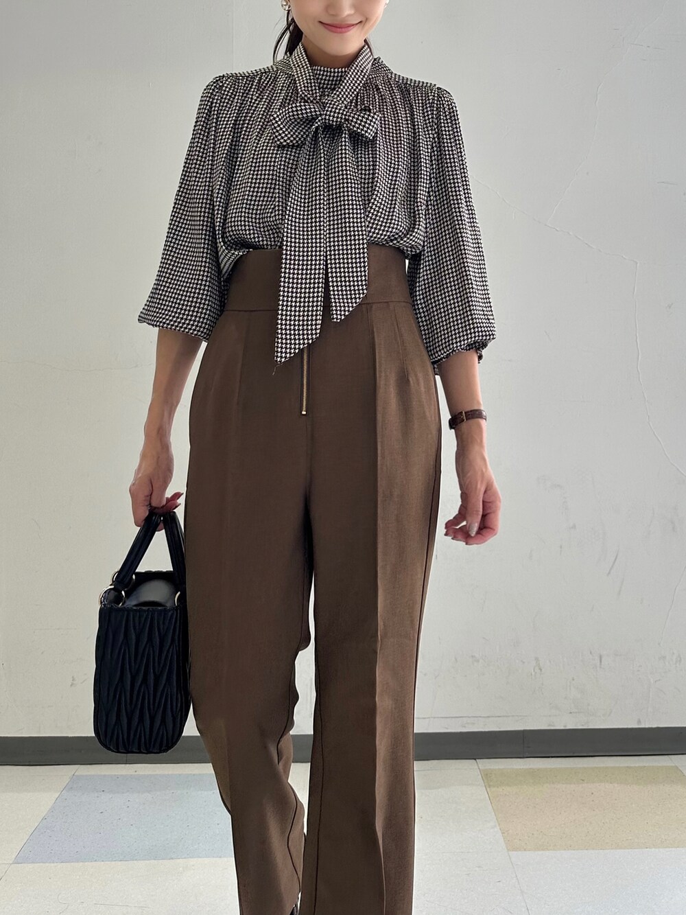 ブラウン系のシャツ/ブラウス、ブラウン系のスラックス、ブラック系のショルダーバッグを着用したレディースの夏コーディネートの3枚目の写真